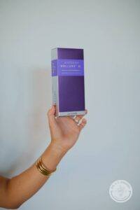 Practitioner Jessica Abbott's arm holding a package of Juvéderm Vollure XC 2.0 x 1.0 mL