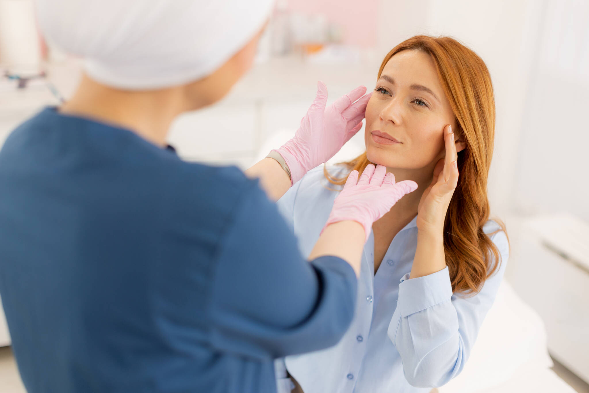 Doctor examines a woman's face to see which treatment is best for her cosmetic goal.