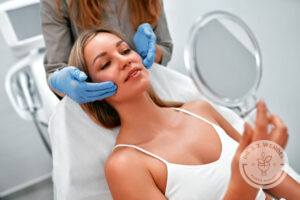 Woman's face is examined as she is told about buccal fat removal and filler options.