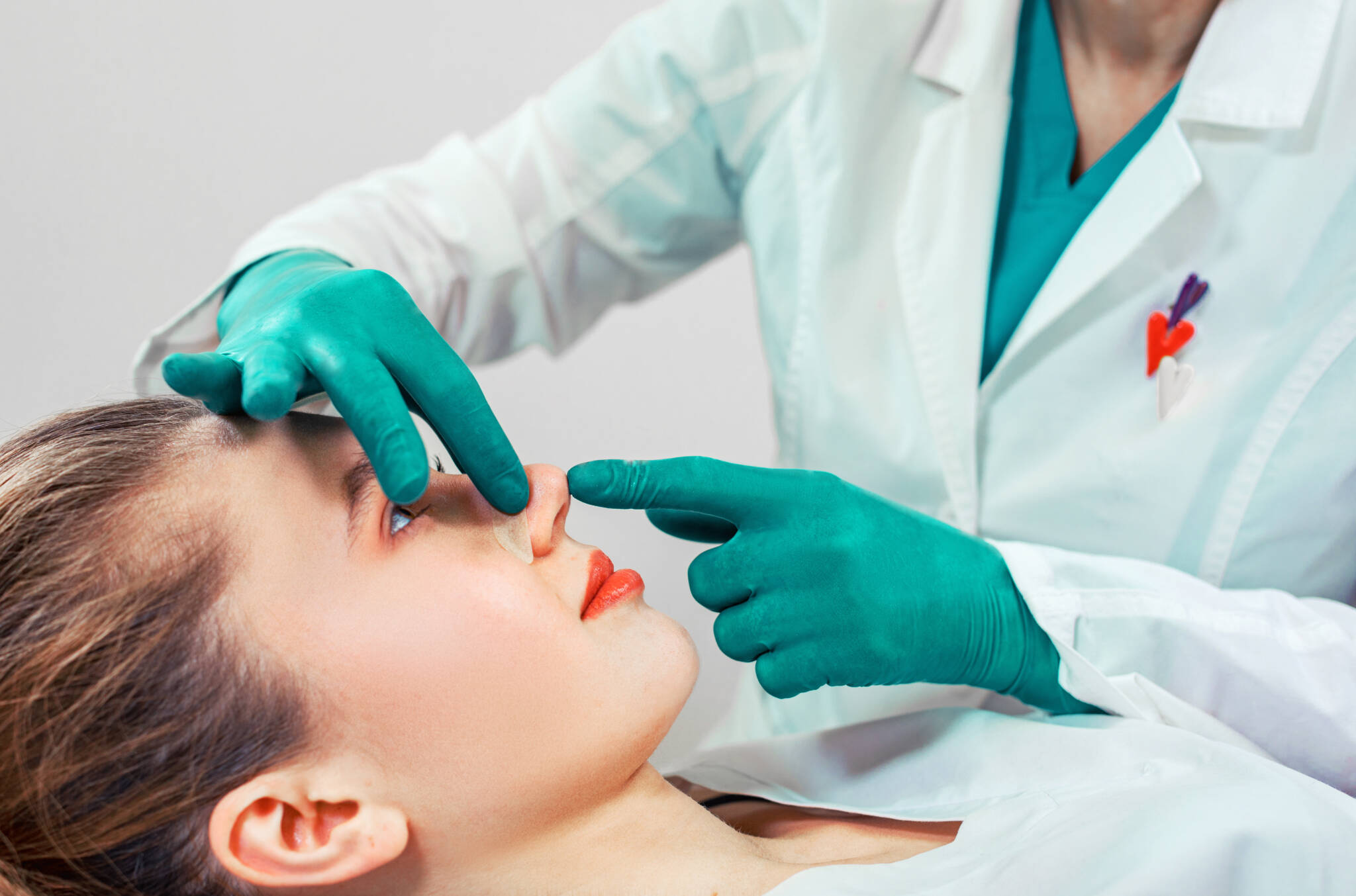 Women has her nose examined after a rhinoplasty surgery.