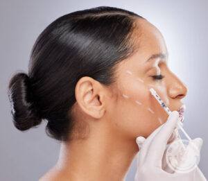 Woman receives injectable neurotoxin to relax facial muscles and reduce the appearance of wrinkles.