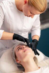 Woman receiving a liquid facelift treatment with facial filler injections at a cosmetic clinic