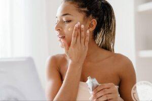 Woman applying medical-grade facial skincare cream as part of a skincare routine for her skin type.