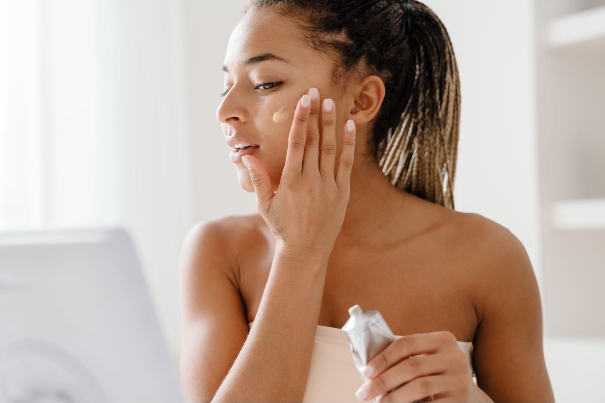 Woman applying medical-grade facial skincare cream as part of a skincare routine for her skin type.