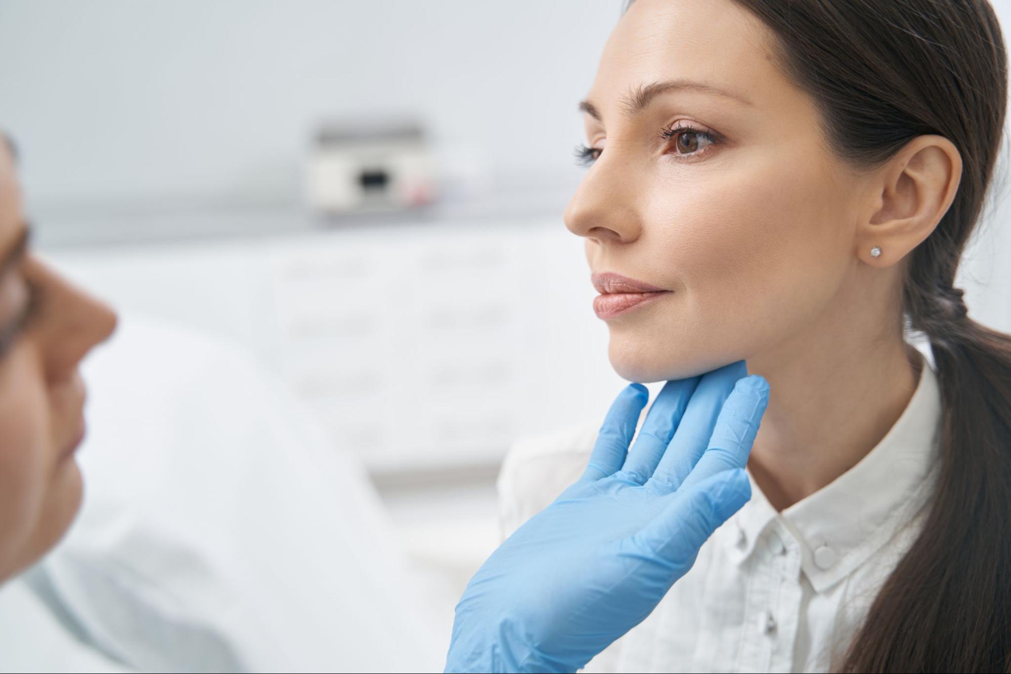 Woman receiving Volux jawline filler treatment from a plastic surgeon