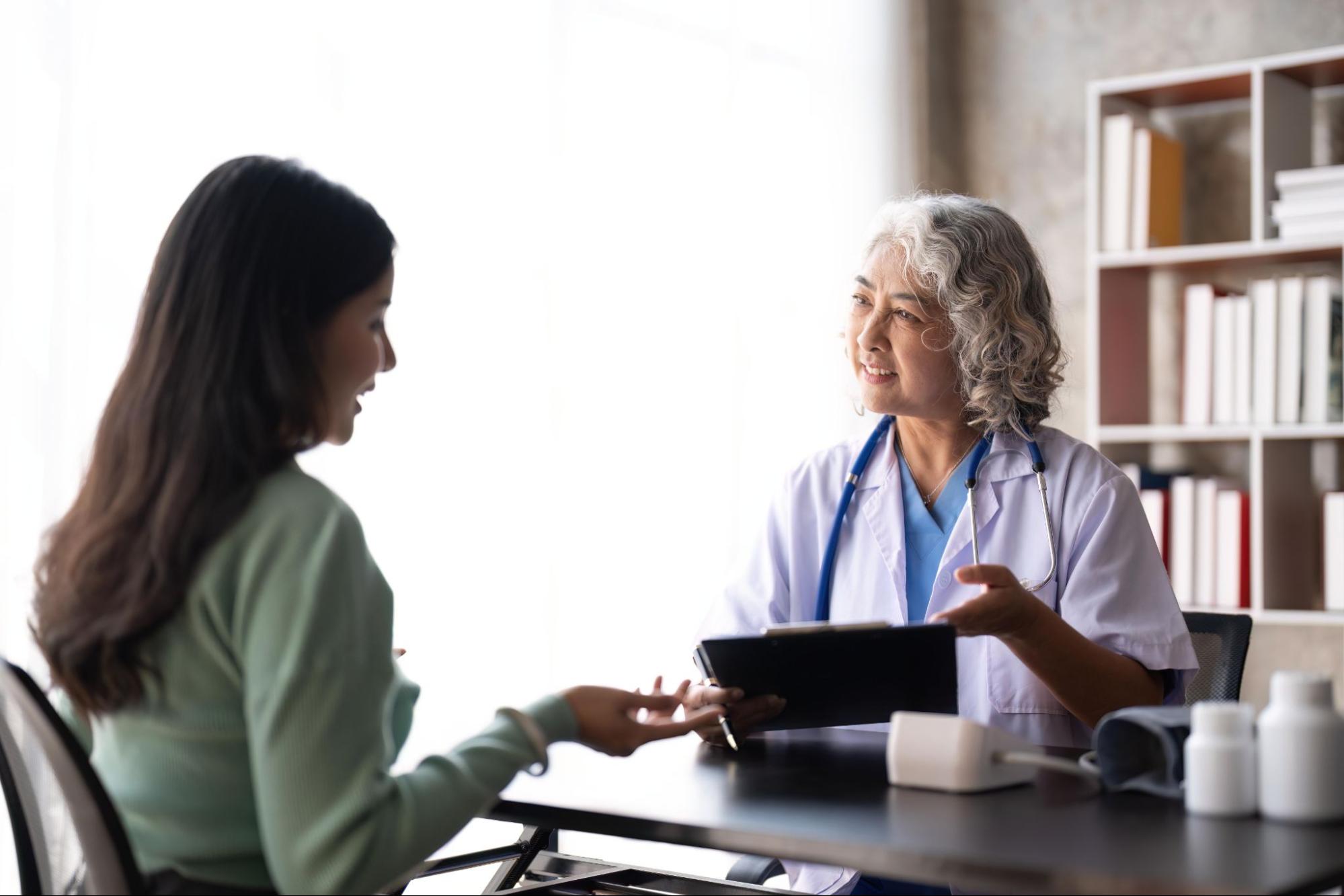 Plastic surgeon discussing breast fat transfer with a patient during a consultation